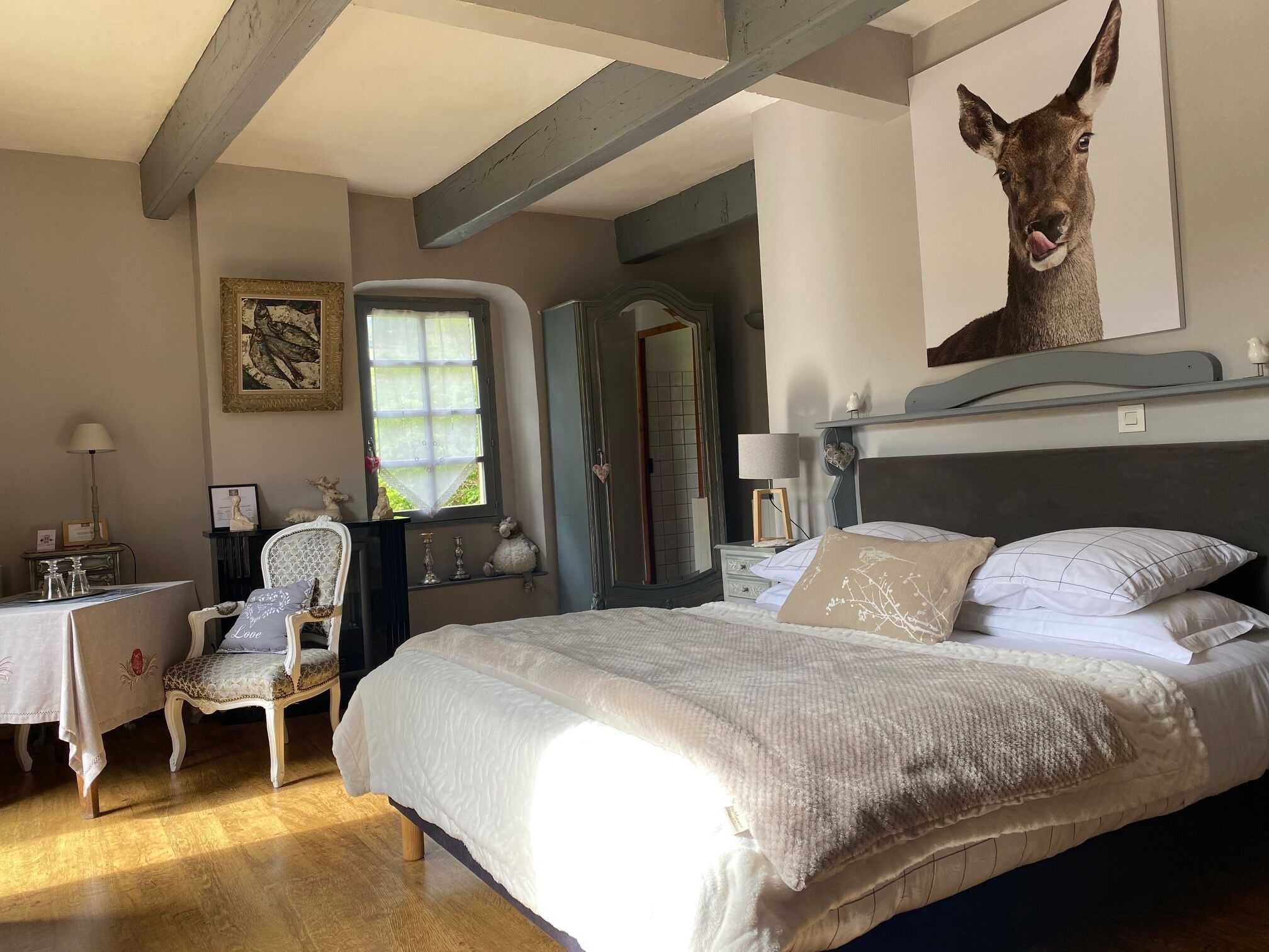 Ein Schlafzimmer mit einem großen Bett, einem Schreibtisch, einem Stuhl und einem Spiegel.