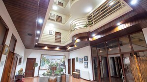 Un'ampia hall con soffitto alto, una fontana decorativa al centro e vista sull'esterno.