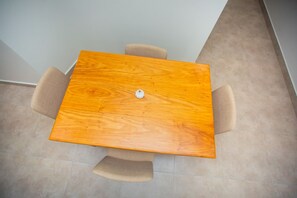 Four chairs surround a central table in a simple, functional space.