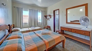 A bedroom with two beds, a wooden dresser, a mirror, and a fan. - Casa com Piscina no Iguape 50m do Mar (Aquiraz)