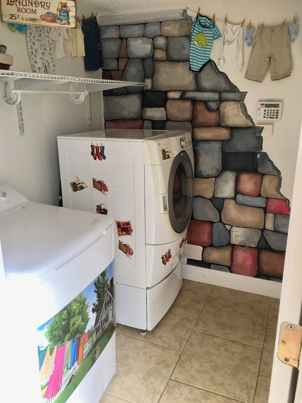 A laundry room with a stone wall, a washing machine, and a dryer.