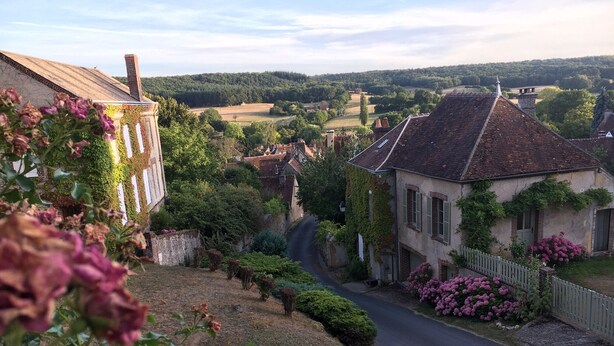 A rural village with a narrow road, traditional houses, and lush greenery. - Take a break "Au fil de l'ô (Moutiers-au-Perche)