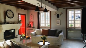 A living room with a fireplace, two sofas, a coffee table, and a clock on the wall. - Take a break "Au fil de l'ô (Moutiers-au-Perche)