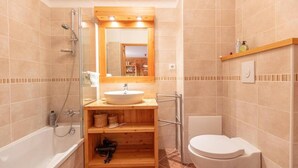 A modern bathroom with a bathtub, a sink, a toilet, and a shower.