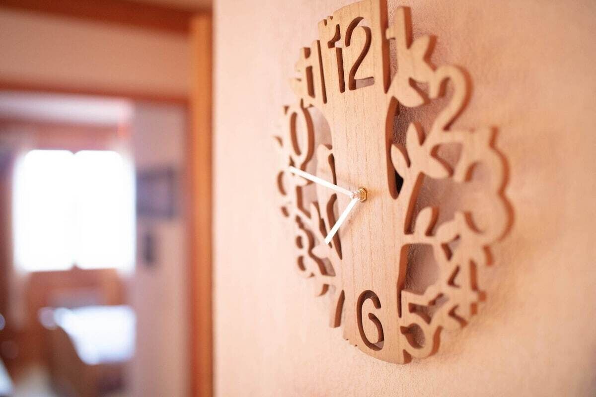 Un reloj de pared de madera con diseños intrincados recortados.