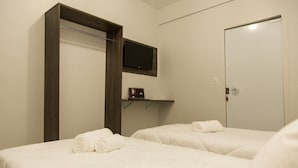 A hotel room with two beds, a TV mounted on the wall, and a door. - Smart Hotel Rio Verde (Rio Verde)