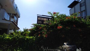 Un edificio con un cartello che riporta la scritta "NIRVANA HOTEL" e un'auto parcheggiata davanti.
