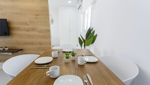 A dining table set with plates, cups, cutlery, and a small plant.