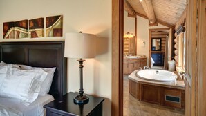 A bedroom with a bed, a bedside table with a lamp, and a painting on the wall.