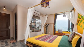 Una habitación con una cama, una ventana con vistas, una puerta y una cortina.