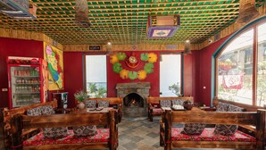Un interior acogedor con muebles de madera, chimenea de piedra y un ventanal grande.