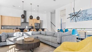 A modern living room with a sectional sofa, a round coffee table, and a yellow armchair. - Red Fish Blue Fish🐟Private Pool Home👙Dogs OK🐶 (Okaloosa Island)