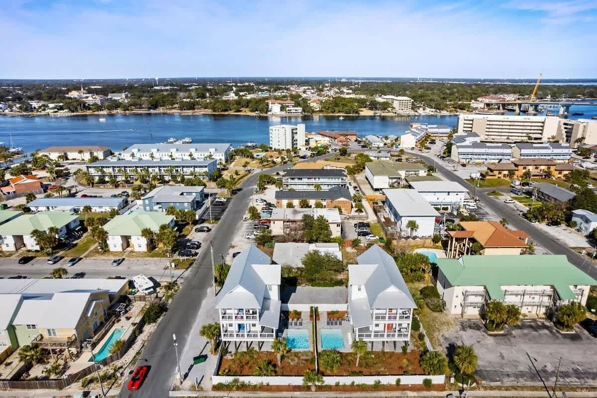 An aerial view of a coastal town with buildings, roads, and a marina.