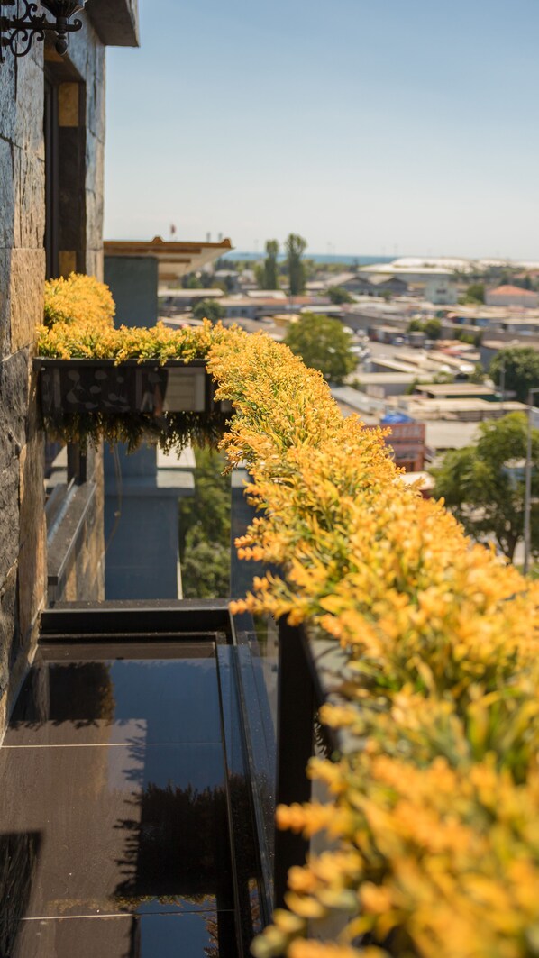 Un edificio con superficie negra reflectante y una fila de flores amarillas a lo largo del borde.