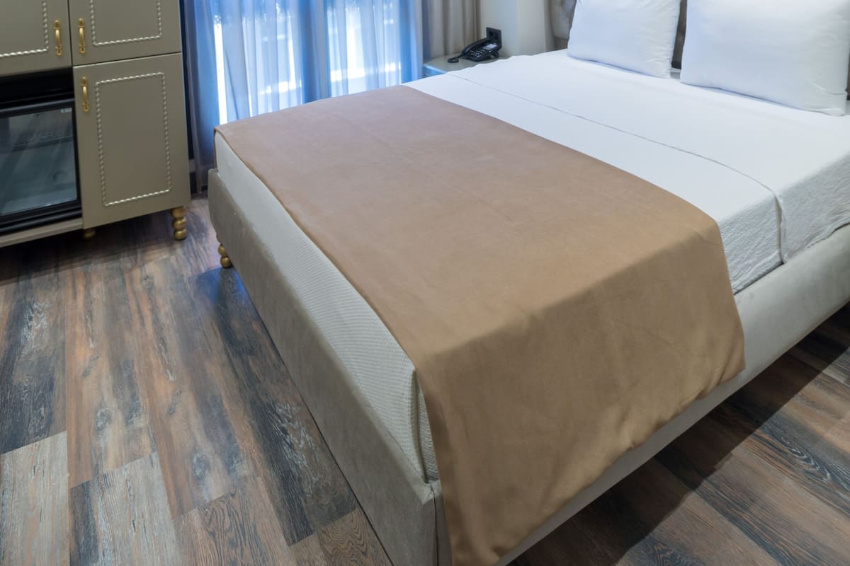 A hotel room with a large bed, a wardrobe, and a television.