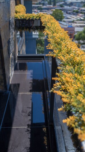 A narrow, reflective glass balcony with yellow flowers on the right side. - Hotel Mardia (Istanbul)