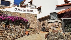 A building with a sign reading 'CASAL DA SERRA' and a stone staircase leading to it. - Casal da Serra (Penha Garcia)