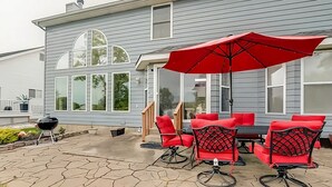 A patio with a red umbrella, outdoor furniture, and a barbecue grill. - Fairway Haven at The Falls – Golf, Shops, Dining! 10-12 Mins. Equestrian Center (O'Fallon)