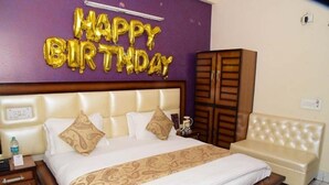 A hotel room with a large bed, a nightstand, a wardrobe, and a sofa. - Hotel R.K. Regency (Rohtak)