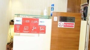 A reception desk with a 'No Smoking' sign, a glass counter, and a 'Reception' sign. - Hotel R.K. Regency (Rohtak)