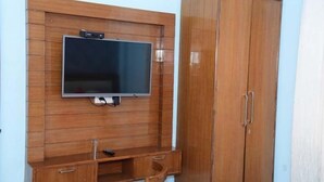A wooden cabinet with a flat-screen TV mounted on it. - Hotel R.K. Regency (Rohtak)