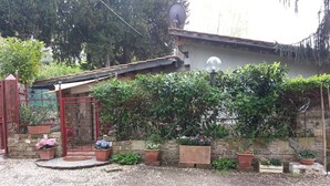 A rustic house with a gravel driveway, a metal gate, and potted plants. - MONIC83 Gechetto Studio at Lake Bracciano - Trevignano  (trevignano romano)
