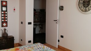 A bedroom with a bed, a clock, and a wardrobe. - MONIC83 Gechetto Studio at Lake Bracciano - Trevignano  (trevignano romano)