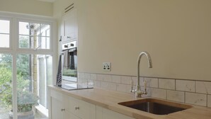 A modern kitchen with a large window, white cabinetry, and a stainless steel sink. - 1 bedroom accommodation in Todenham, near Moreton-in-Marsh (Todenham, near Moreton-in-Marsh)