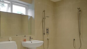 A bathroom with a white sink, a toilet, and a shower area. - 1 bedroom accommodation in Todenham, near Moreton-in-Marsh (Todenham, near Moreton-in-Marsh)
