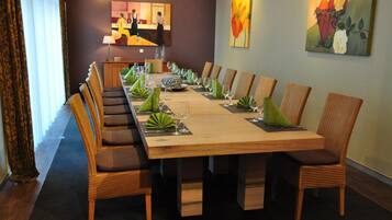A conference room with a long table set for a meeting, surrounded by chairs.