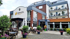 Un hotel con posti a sedere all'aperto e un'insegna con la scritta 'Parkhotel'.