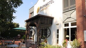 Edificio del Parkhotel con insegna, posti a sedere all'aperto e sedie a rotelle.
