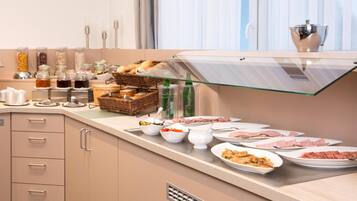 Una mesa de buffet con diversos alimentos, incluyendo carnes, verduras y salsas.