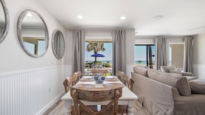 A modern living room with a dining area, large mirrors, and a view of the ocean. - Latitude 14 - NEW OWNER! NEW LOOK! Spectacular ocean views! 1BD/2BA. Sleeps 6 (Panama City Beach)