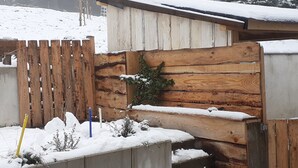A wooden fence with snow on the ground and a building in the background. - "Vacation cottage Plättig" (Bühlertal)