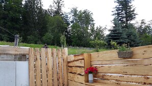 A wooden gate leading to a wooden bench with a potted plant. - "Vacation cottage Plättig" (Bühlertal)