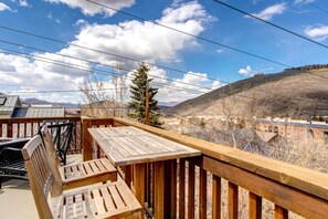 A wooden deck with a view of a mountainous landscape and a building in the distance. - KBM Resorts | Private Home | Split AC in living room | Walk to Town and to Ski Access, Hot Tub and Fire Pit! PNF-860 (Park City)