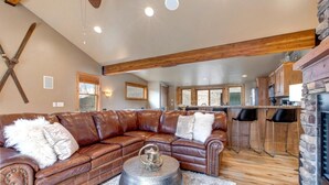 A spacious living room with a leather sectional sofa, a fireplace, and a kitchen area in the background. - KBM Resorts | Private Home | Split AC in living room | Walk to Town and to Ski Access, Hot Tub and Fire Pit! PNF-860 (Park City)