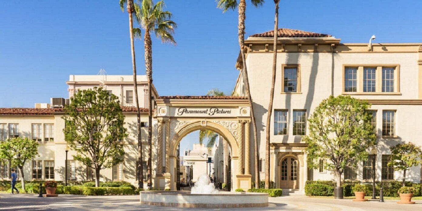 A building with a sign reading "Paramount Pictures" and a fountain in the center.