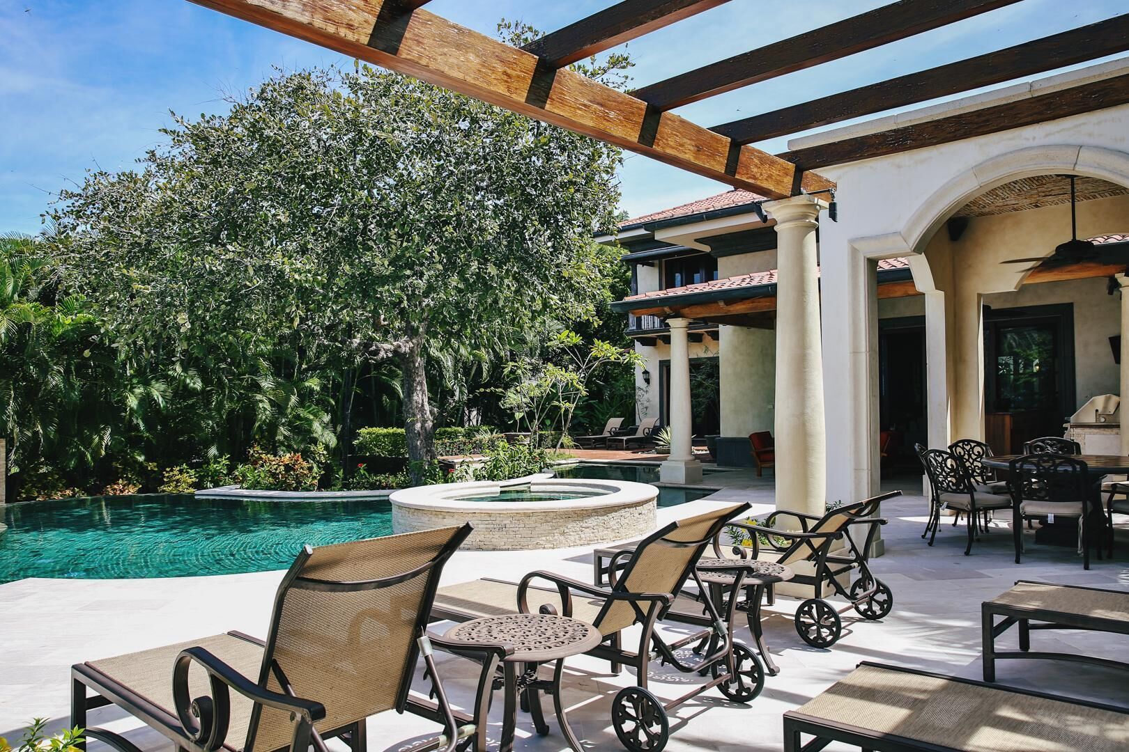 A poolside area with outdoor seating and a pergola.