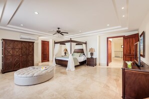 A spacious bedroom with a four-poster bed, a ceiling fan, and a large ottoman. - Crystal Sands 504 (Tamarindo)