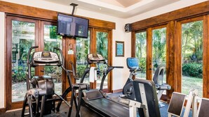 A home gym with treadmills, a stationary bike, and a TV mounted on the wall. - Villa Mansita (Tamarindo)