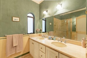 Un baño con dos lavamanos, un espejo grande y una ventana.