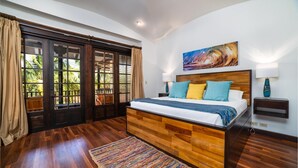 Ein Schlafzimmer mit einem hölzernen Bett, einem farbenfrohen Teppich, einem großen Fenster mit Vorhängen und einem Gemälde an der Wand.