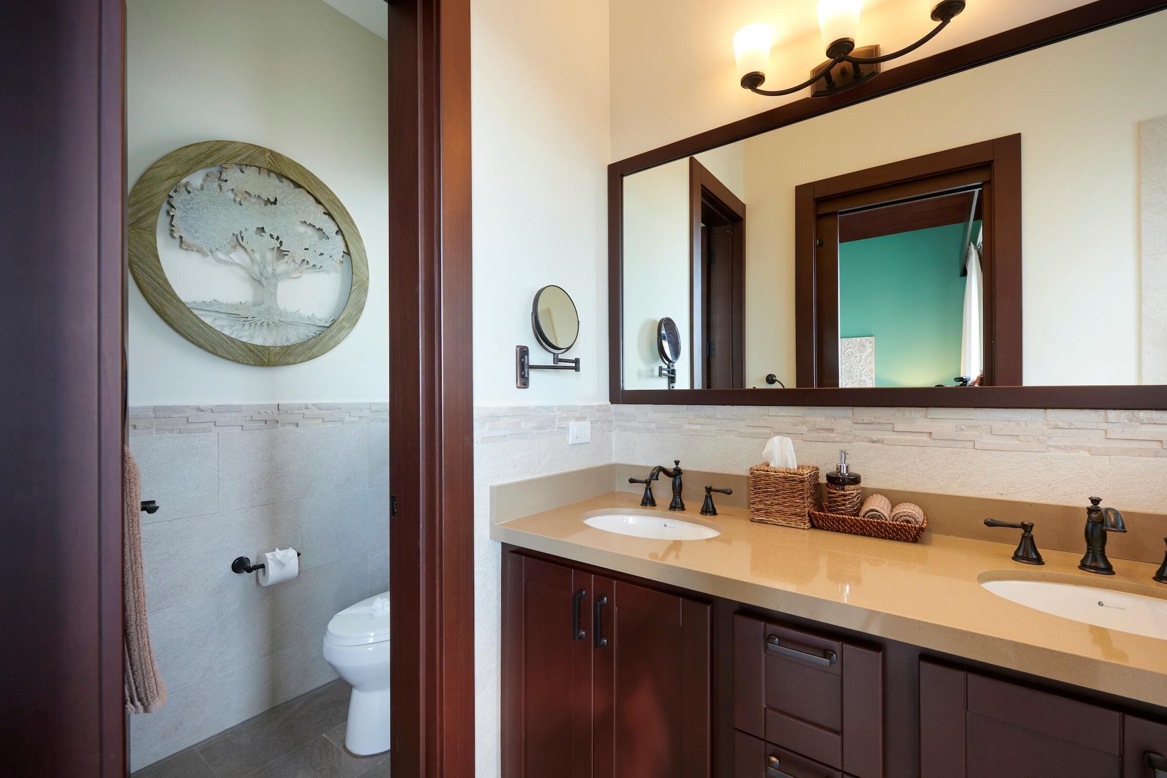 A bathroom with two sinks, a large mirror, and a toilet.