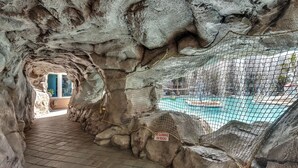 Ein Kletterbereich im Innenbereich mit Schwimmbecken und einem Schild, das das Klettern an den Felsen verbietet.