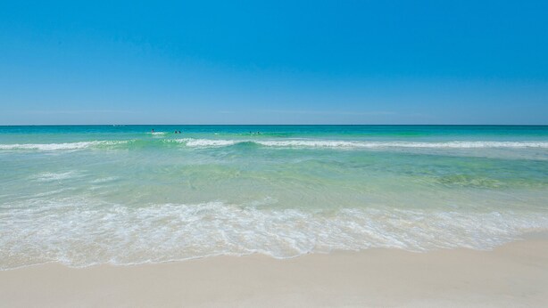 Ein Strand mit klarem türkisblauem Wasser und einem Sandstrand.