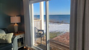 A room with a view of the ocean through a sliding glass door. - Islands View Condo- Waterfront (Saint Ignace)