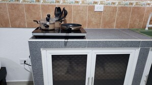 A kitchen with a stove, pots, and a sink. - Zac NicteMx House / ESTUDIO SISAL (Cancun)