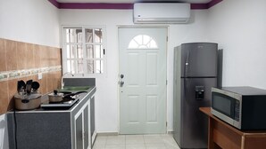 A compact kitchen with a stove, sink, refrigerator, and microwave. - Zac NicteMx House / ESTUDIO SISAL (Cancun)